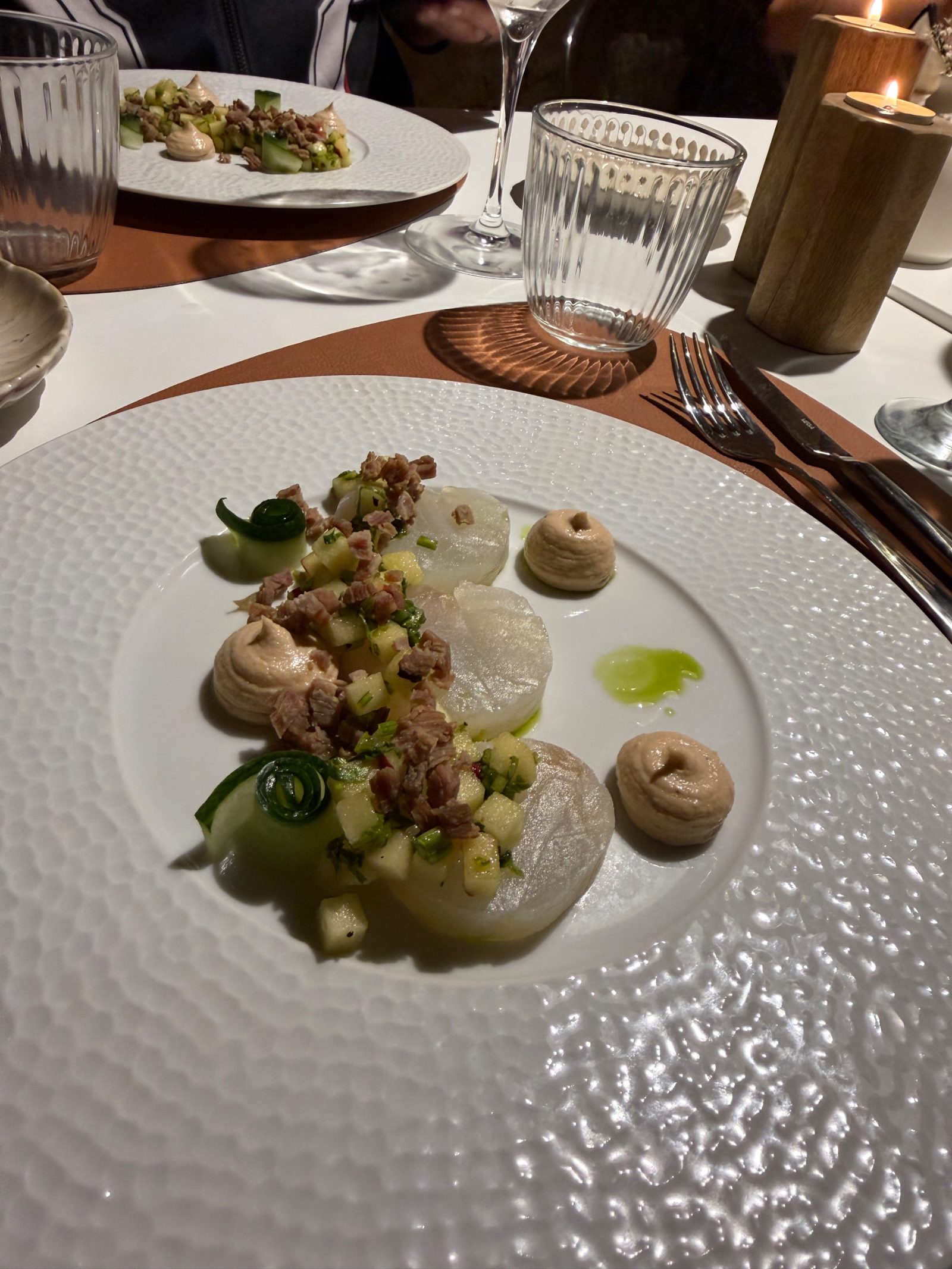 Noix de Saint-Jacques du menu de fête, sur une table aux chandelles du Pressoir